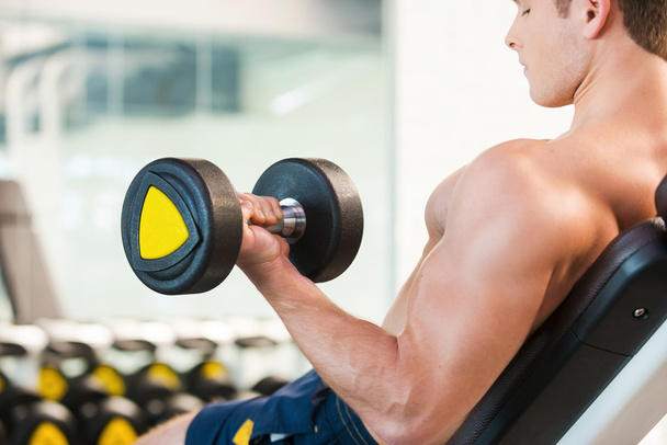 Muscular man training with dumbbell - Photo, Image