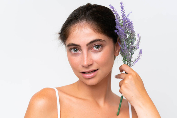Young Pretty caucasian woman isolated on white background holding a lavender plant. Close up portrait - Fotó, kép
