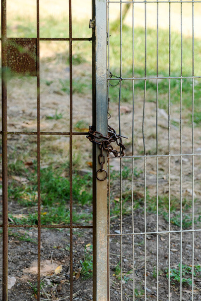 Locked with a chain metal gate on a rural pasture close-up - 写真・画像