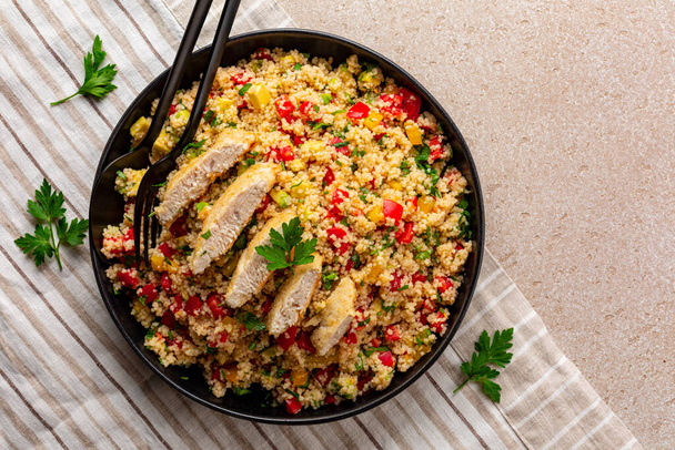 Couscous salad with Chicken breast and vegetables, tomatoes, avocado, bell pepper, parsley and lemon juice. Directly above. - Zdjęcie, obraz