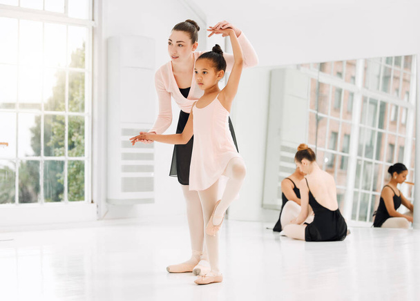 Folytasd azzal, amit hallasz. Egy kislány balettozik a tanárával egy táncstúdióban. - Fotó, kép
