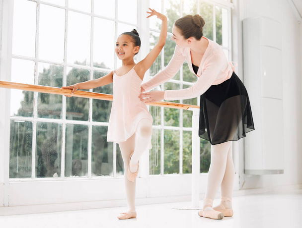 Its all in the posture. a little girl practicing ballet with her teacher in a dance studio - Zdjęcie, obraz