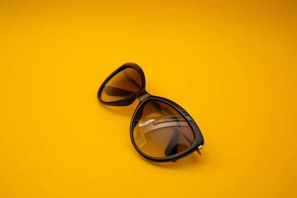 Black s sunglasses on orange background - Foto, imagen
