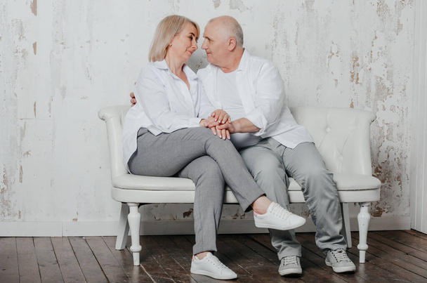 egy férfi és a felesége fehér ingben egy fotóstúdióban - Fotó, kép