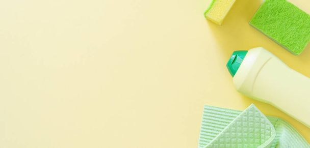 Cleaning concept - cleaning supplies on pastel yellow background, top view - Foto, immagini