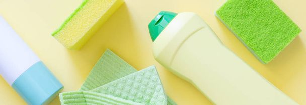 Cleaning concept - cleaning supplies on pastel yellow background, top view - Foto, immagini
