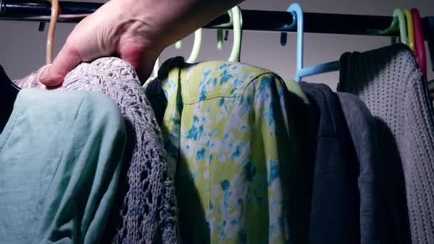 Looking for outfit on clothes hung on a rail medium 4k shot slow motion selective focus - Imágenes, Vídeo