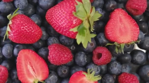Blueberry, Strawberry and Raspberry, rotating backdrop. close-up. Blueberry and Raspberry with green leaf on rotating backdrop. close-up. Berries. Various colorful berries rotation background.Bio - Video