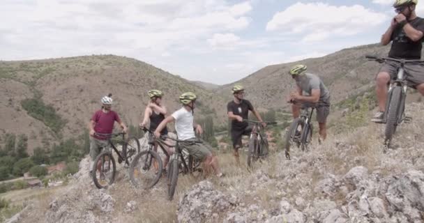 Group of friends are talking while standing and taking a break on the uphill - Filmati, video