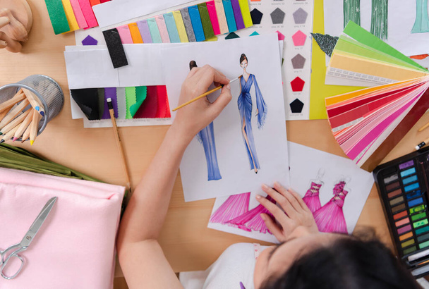 mode-ontwerper stijlvolle tekeningen schetsen textiel materiaal Kostuum. Ontwerper creatieve workshop studio. - Foto, afbeelding