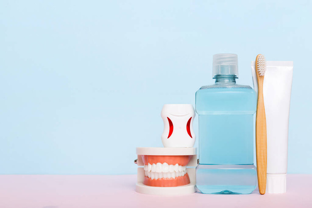 Mundspülung und andere Mundhygieneprodukte auf farbiger Tischplatte mit Kopierraum. Flach lag er. Zahnhygiene. Mundpflege-Set. Zahnarztkonzept. - Foto, Bild