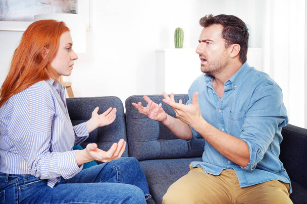Upset and sad couple arguing with each other on sofa - Photo, Image