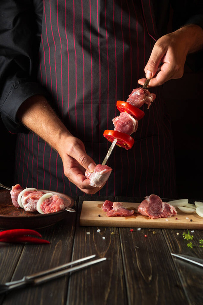 The process of cooking shish kebab from raw lamb meat in the kitchen with the hands of a chef. Asian traditional cuisine - Φωτογραφία, εικόνα