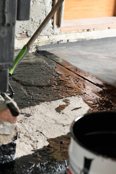 Impermeabilizzazione del pavimento in una casa privata, applicazione di resina liquida al pavimento, massetto di cemento e impermeabilizzazione, riparazione e lavori di costruzione. - Foto, immagini