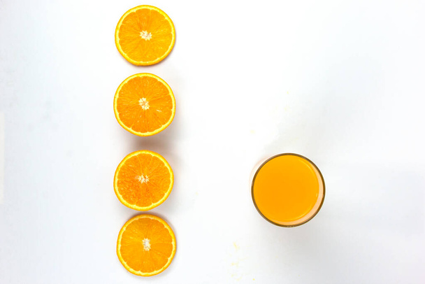 Аранжування шматків соковитих апельсинів зі склянкою апельсина ізольовані на білому тлі, стиль концепції зверху
 - Фото, зображення