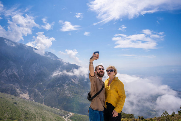 happy hiking couple taking selfie together on top of mountain. - 写真・画像