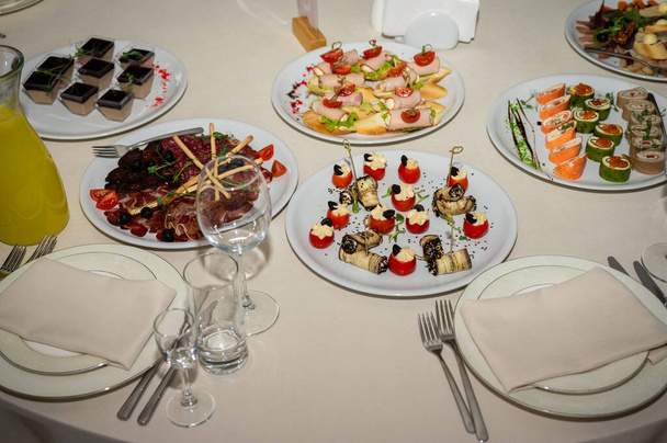 The banquet table. Tableware. Food, snacks, fruits, drinks - Foto, imagen