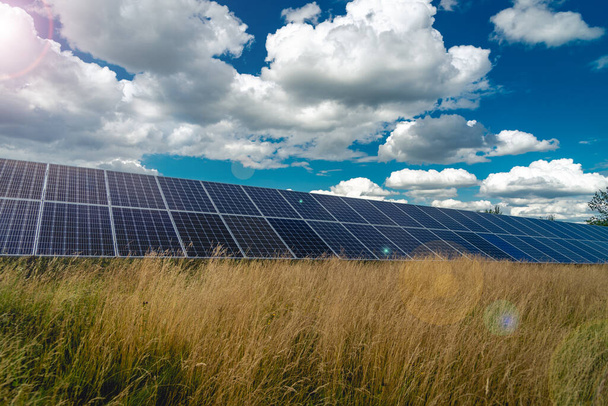 Solar panels and blue sky with clouds and green grass - Foto, afbeelding
