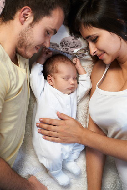 newborn lies between loving father and mother - Foto, Bild