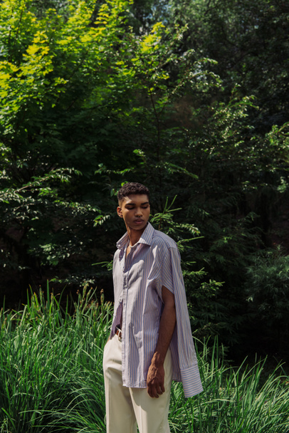 young african american man in fashionable shirt posing in summer park - Foto, Bild