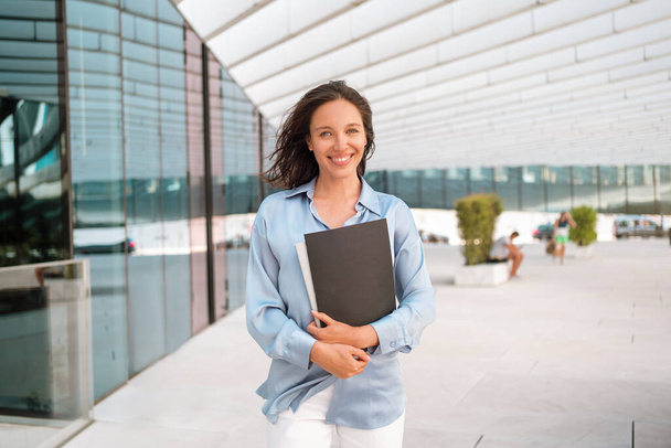 Businesswoman successful woman business person walking outdoor corporate building exterior Excited happy caucasian positive professional business female person holding folder documents Looking camera - Fotografie, Obrázek
