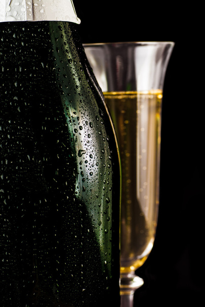 bottle of champagne with a glass closeup  - Fotó, kép