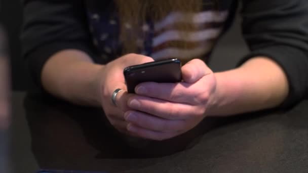 Male hands using a smartphone on the background of a sweatshirt with the USA flag. Communication, online shopping, chat, social media concept. Close-up - Felvétel, videó