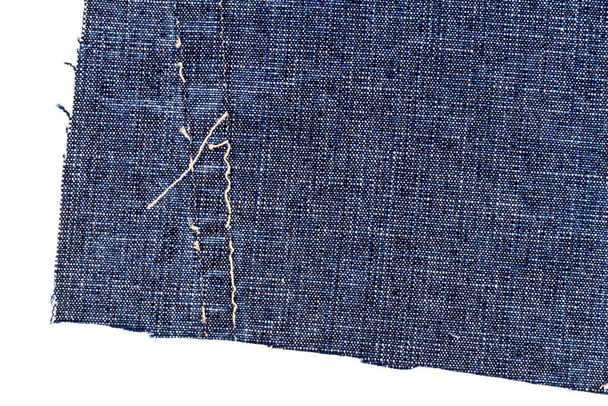 Piece of blue jeans fabric with a ripped of back pocket isolated on white background. Rough uneven edges. Denim fabric torn. - Fotografie, Obrázek