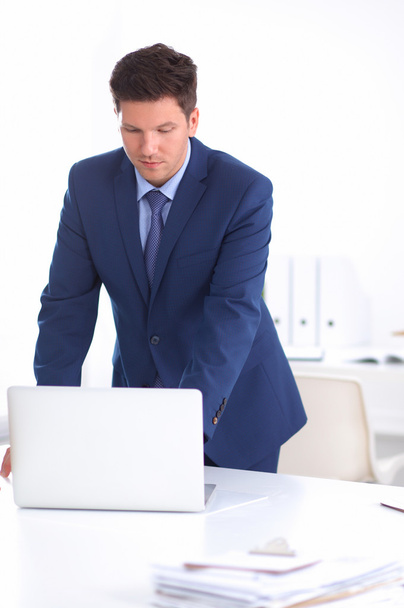 Confident successful young businessman leaning arms on his desk - Photo, Image