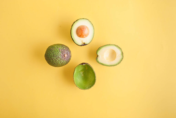 вид зверху, студійне фото авокадо ізольовано на жовтому фоні
  - Фото, зображення