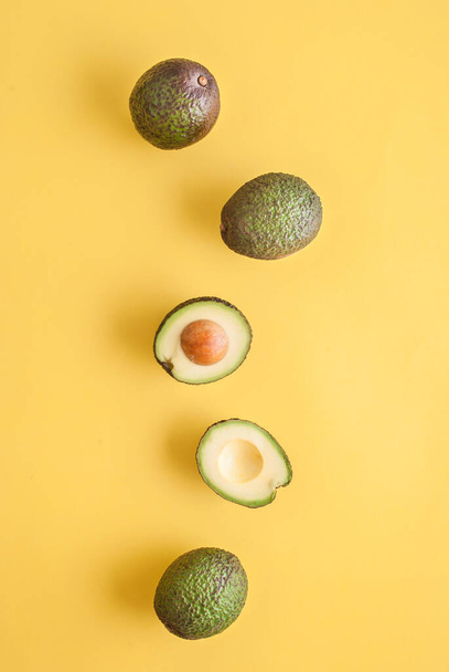 top view, studio photo of avocadoes isolated on yellow background  - 写真・画像