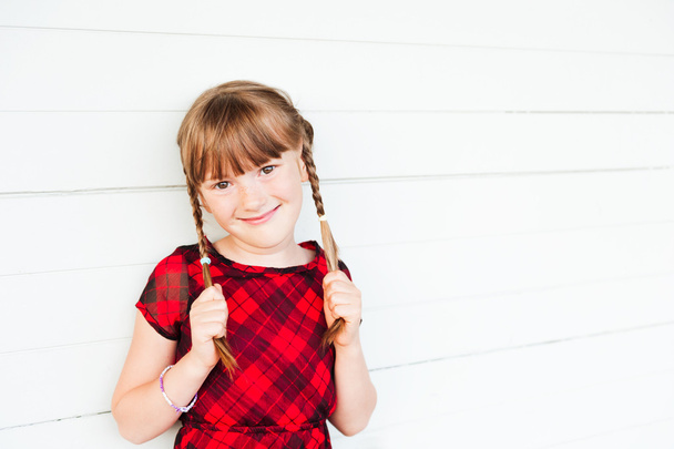 Außenporträt eines niedlichen kleinen Mädchens vor weißem Hintergrund - Foto, Bild