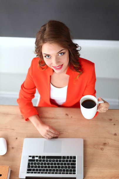 Attractive woman sitting at desk in office, working with laptop computer - Foto, immagini
