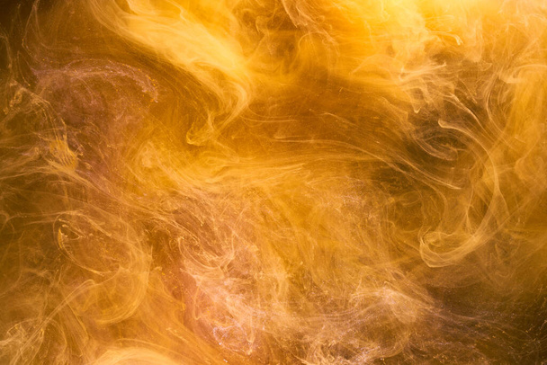 Tekutá tekutina umění abstraktní pozadí. žluté tančící akrylové barvy pod vodou, vesmírný kouř oceán - Fotografie, Obrázek