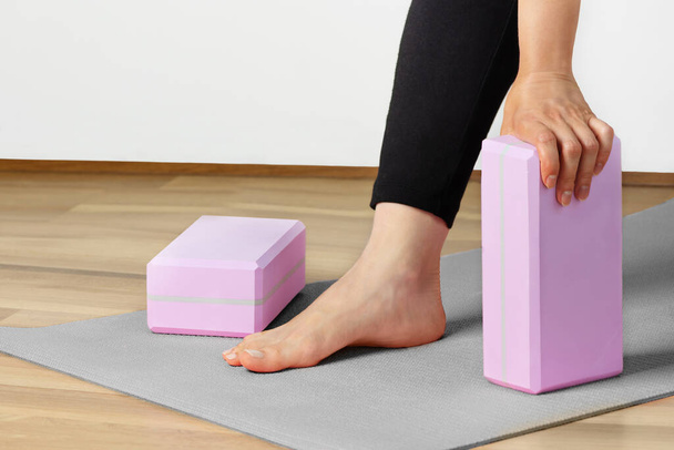 Woman yoga workout with yoga blocks on yoga mat indoor. Healthy lifestyle. - Fotoğraf, Görsel