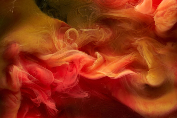 Liquid fluid art abstract background. Red, yellow dancing acrylic paints underwater, space smoke ocean, color explosion - Foto, imagen