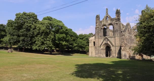 The famous Kirkstall Abbey showing the ruined Cistercian monastery in Kirkstall in the north-west of Leeds city centre in West Yorkshire in the UK on a bright sunny summers day. - Felvétel, videó
