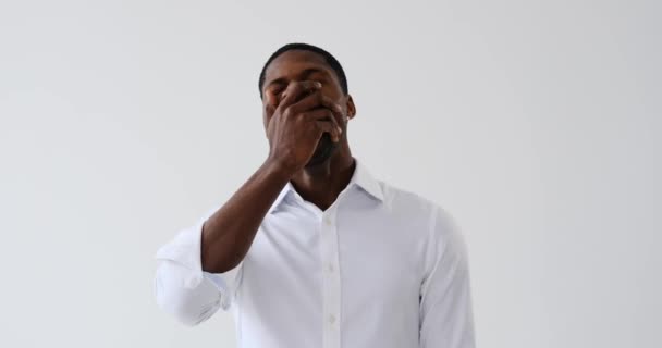 Tired African American businessman yawning over white background - Πλάνα, βίντεο