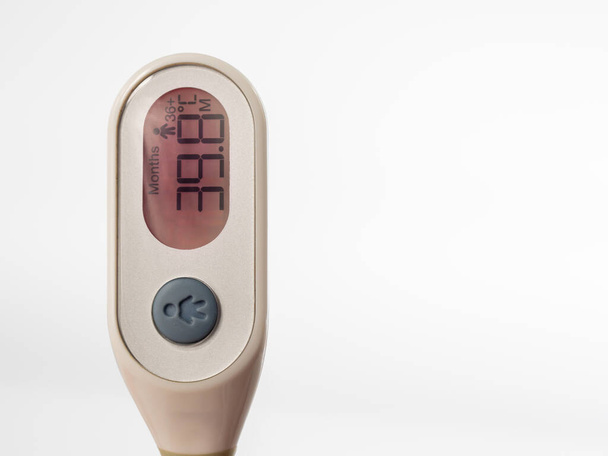 Teploměr pro měření tělesné teploty ukazuje vysokou teplotu. Lékařský digitální teploměr na bílém pozadí. - Fotografie, Obrázek