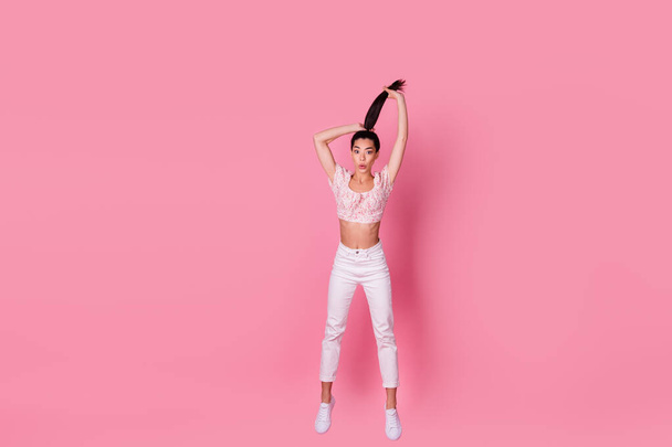Full size photo of crazy young brunette lady jump wear crop top jeans shoes isolated on pink color background. - Foto, Imagem