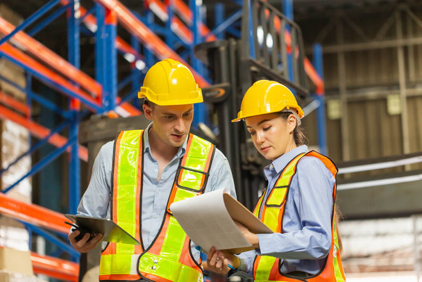 Manager and supervisor taking inventory in warehouse, Female foreperson making plans with warehousemen, Workers working in warehouse - Foto, immagini