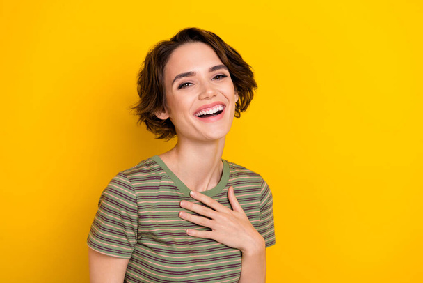 Portrét mladé ženy smích vtip dotýkání hrudníku izolované na jasně žluté pozadí. - Fotografie, Obrázek