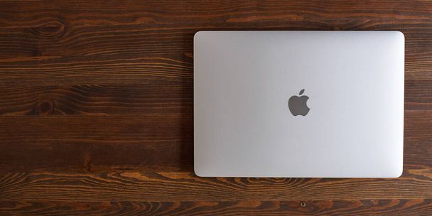 UK, Newcastle upon Tyne, 20 July 2022 - MacBook Air in gray lies closed on a wooden table. MacBook Air 2020-2022. New macBook Air with M1 processor.  - 写真・画像