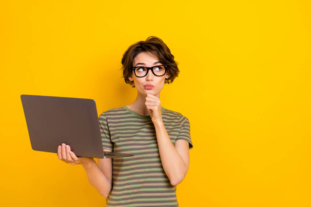 Photo of cute dreamy girl dressed green t-shirt eyewear arm chin typing modern gadget empty space isolated yellow color background. - 写真・画像