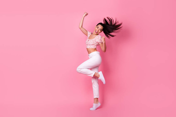 Full length portrait of cheerful delighted vietnamese girl raise fists triumph isolated on pink color background. - Фото, изображение