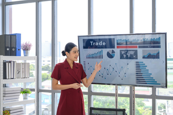 Молода ділова жінка дає доповідь бізнес-команді в конференц-залі, показує цифрову інформаційну графіку, п'єси про зростання компанії на телебаченні
 - Фото, зображення