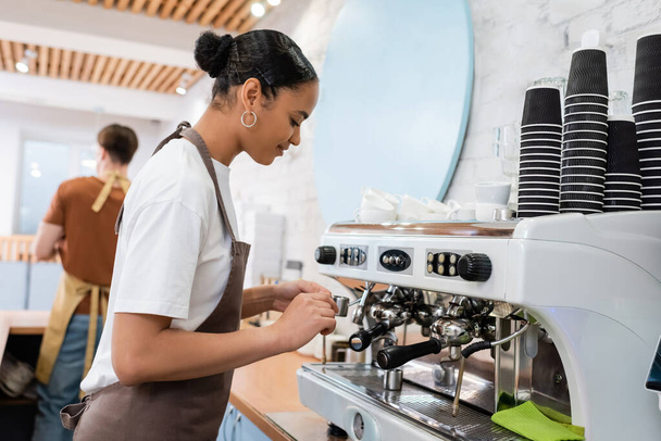 African american barista making coffee near machine in confectionery  - Photo, Image