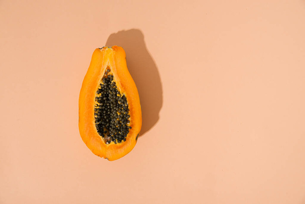 single papaya fruit cutter on half on pastel background. copy space - Photo, Image