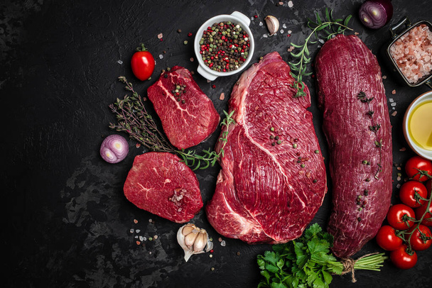 beef meat background fillet steaks with herbs and spices on a dark background. Restaurant menu, dieting, cookbook recipe top view, - Fotó, kép