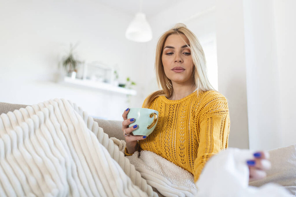 Sick Woman Covered With a Blanket Lying in Bed With High Fever and a Flu, Resting at Living Room. She Is Exhausted and Suffering From coronavirus. Sick Woman With Runny Nose Lying in Bed. - Foto, imagen